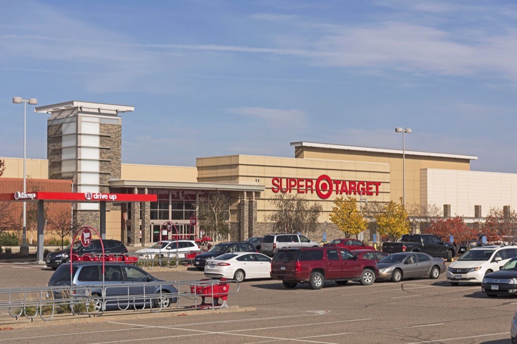 A Super Target store with a parking lot in front, several cars parked, shopping carts, and a drive-up area visible on a clear day.