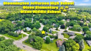 Aerial view of a suburban neighborhood with trees and houses. Text names Bloomington Jefferson High School, Olson Elementary, and Olson Middle School, with yellow icons and a star marking a location.